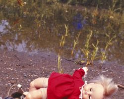 Lost Doll at water side, with three shoes